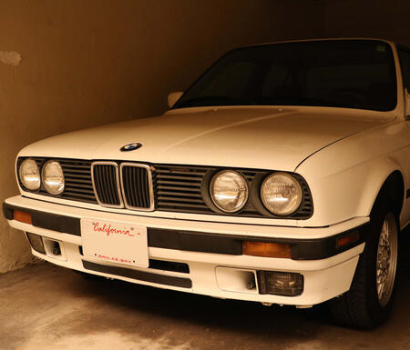 A white car sits in a sepia-toned garage