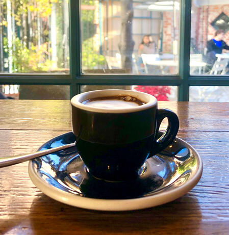 Small coffee cup in front of a vibrant window